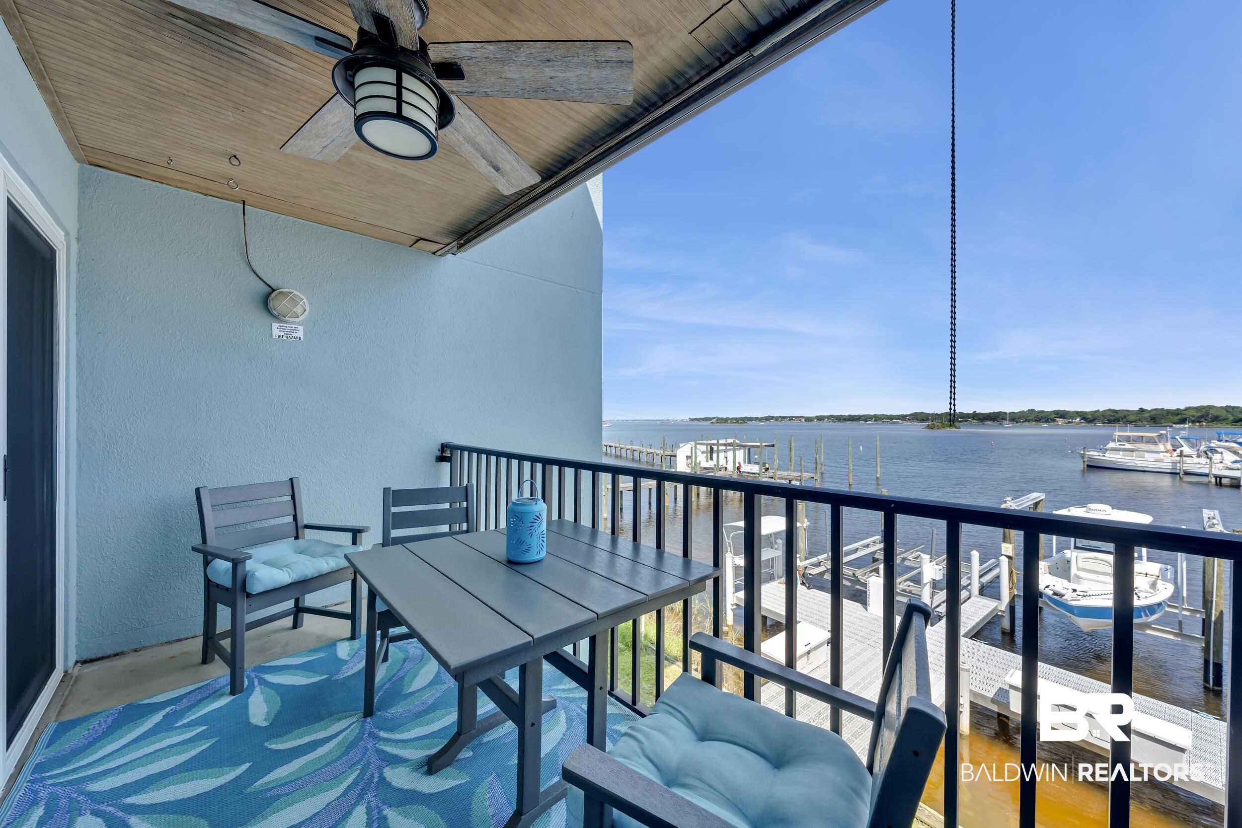 14100 River Road, Unit 211 Pensacola, FL 32507 - Photo 22 of 56 Private balcony featuring a black metal railing and water frontage with boat slips