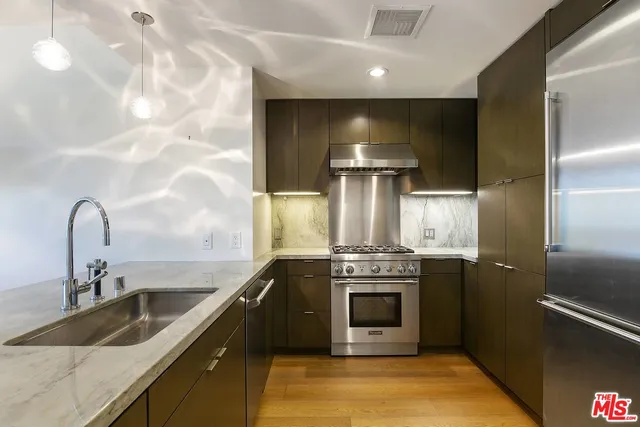 a kitchen with stainless steel appliances a sink a counter space and a view of kitchen