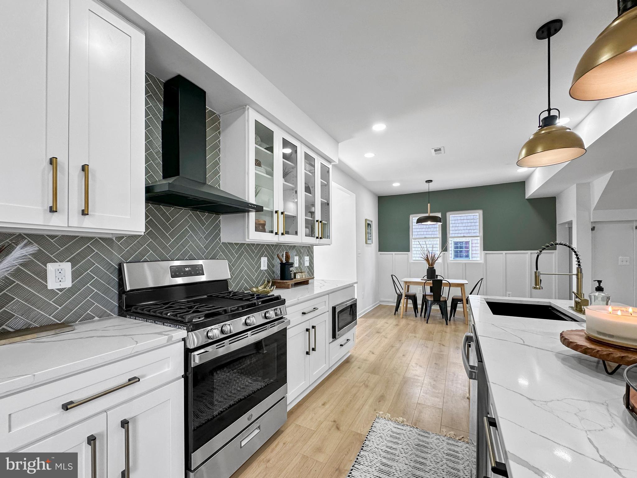 4309 Queensbury Road Riverdale, MD 20737 - Photo 15 of 63 a kitchen with stainless steel appliances granite countertop a stove a sink dishwasher and cabinets with wooden floor