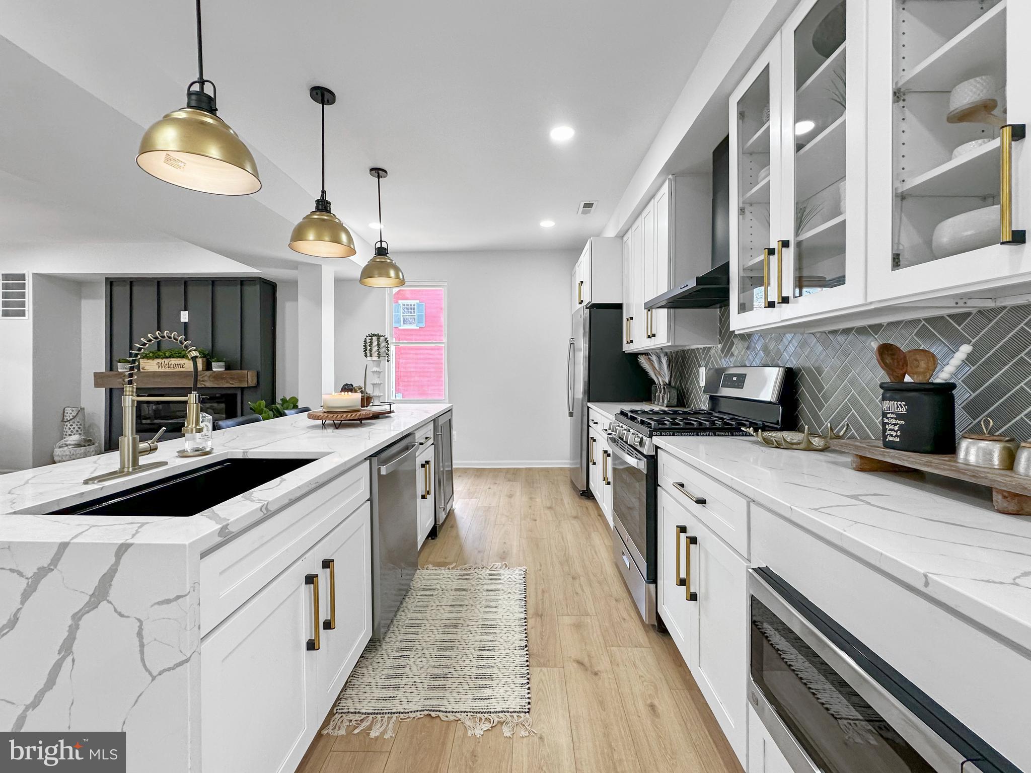4309 Queensbury Road Riverdale, MD 20737 - Photo 17 of 63 a large kitchen with stainless steel appliances kitchen island granite countertop a large counter top and a stove
