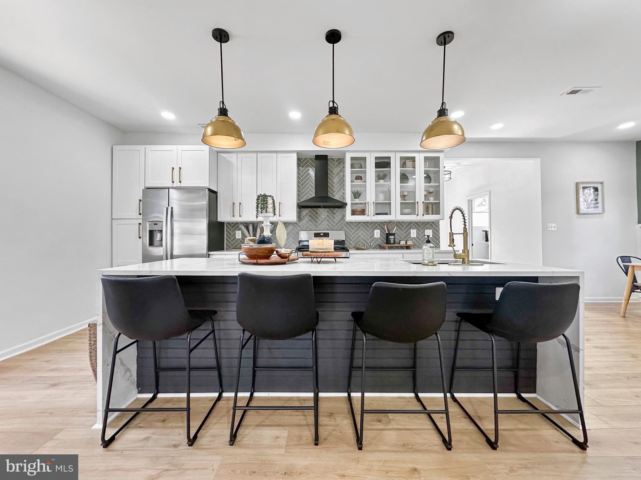 4309 Queensbury Road Riverdale, MD 20737 - Photo 20 of 63 a kitchen with a counter and chairs