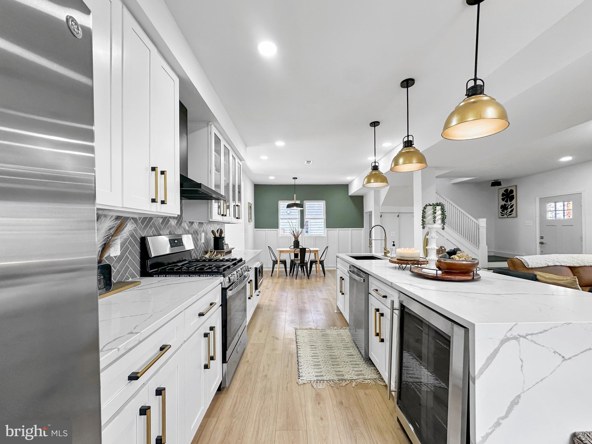 4309 Queensbury Road Riverdale, MD 20737 - Photo 21 of 63 a kitchen with stainless steel appliances kitchen island granite countertop a stove a sink a refrigerator and a cabinets
