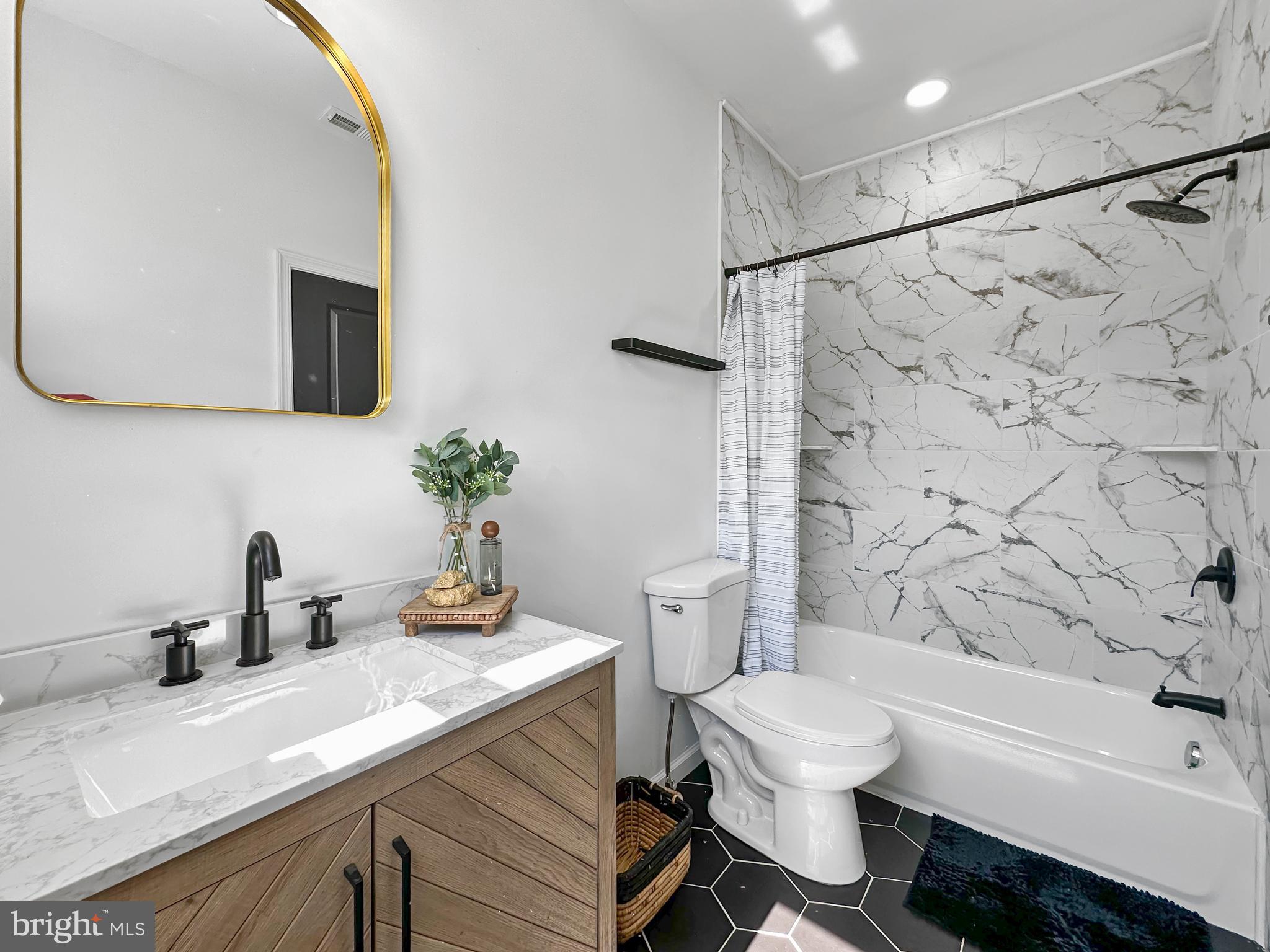 4309 Queensbury Road Riverdale, MD 20737 - Photo 25 of 63 a bathroom with a sink a toilet and a bathtub
