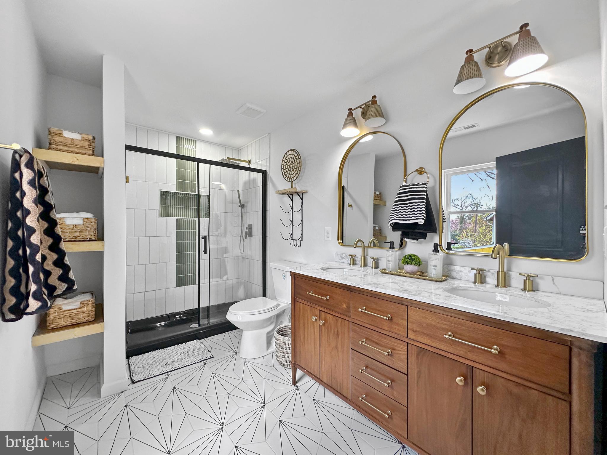 4309 Queensbury Road Riverdale, MD 20737 - Photo 35 of 63 a spacious bathroom with a double vanity sink toilet and shower