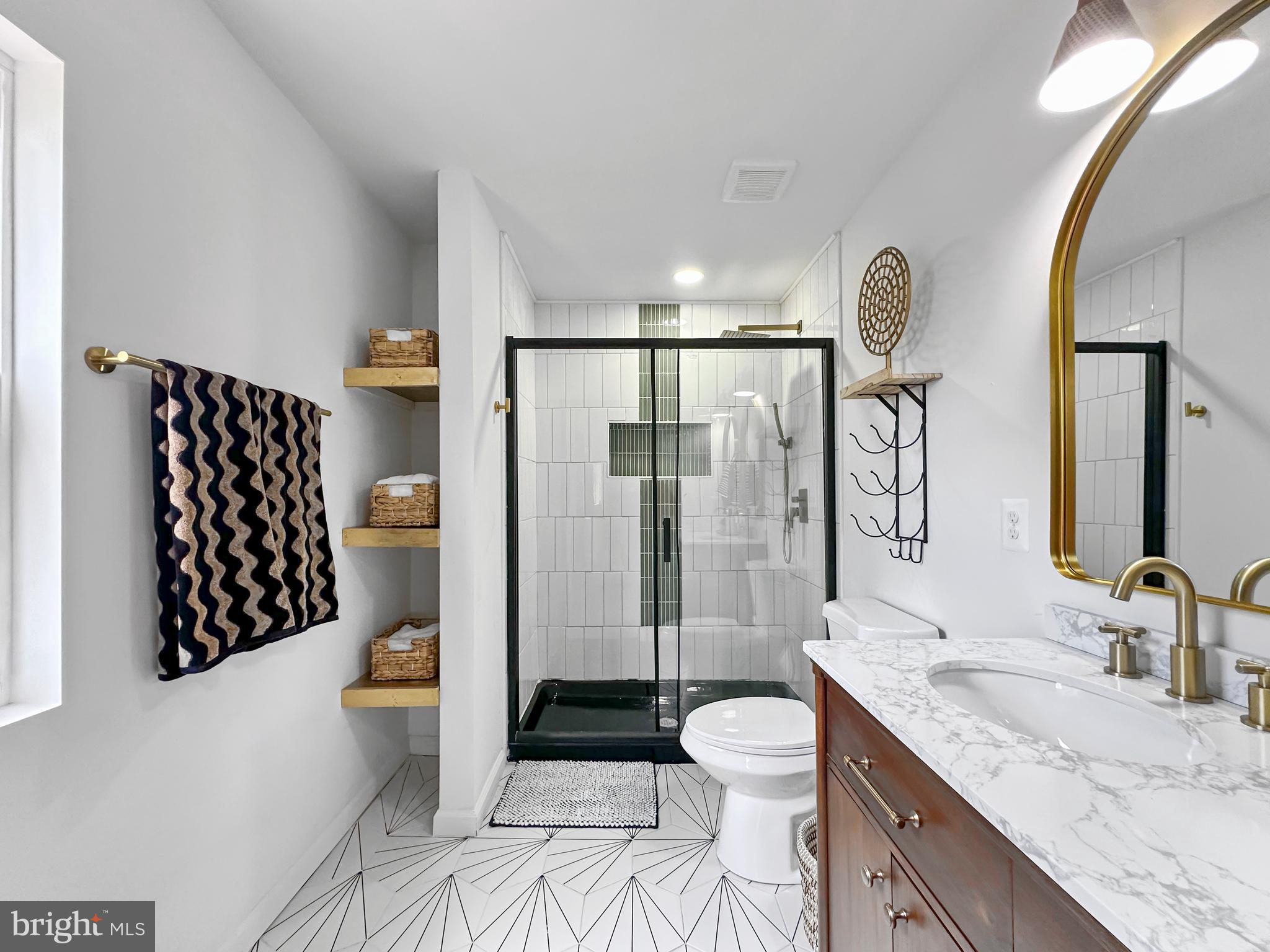 4309 Queensbury Road Riverdale, MD 20737 - Photo 36 of 63 a spacious bathroom with a granite countertop sink toilet mirror and shower