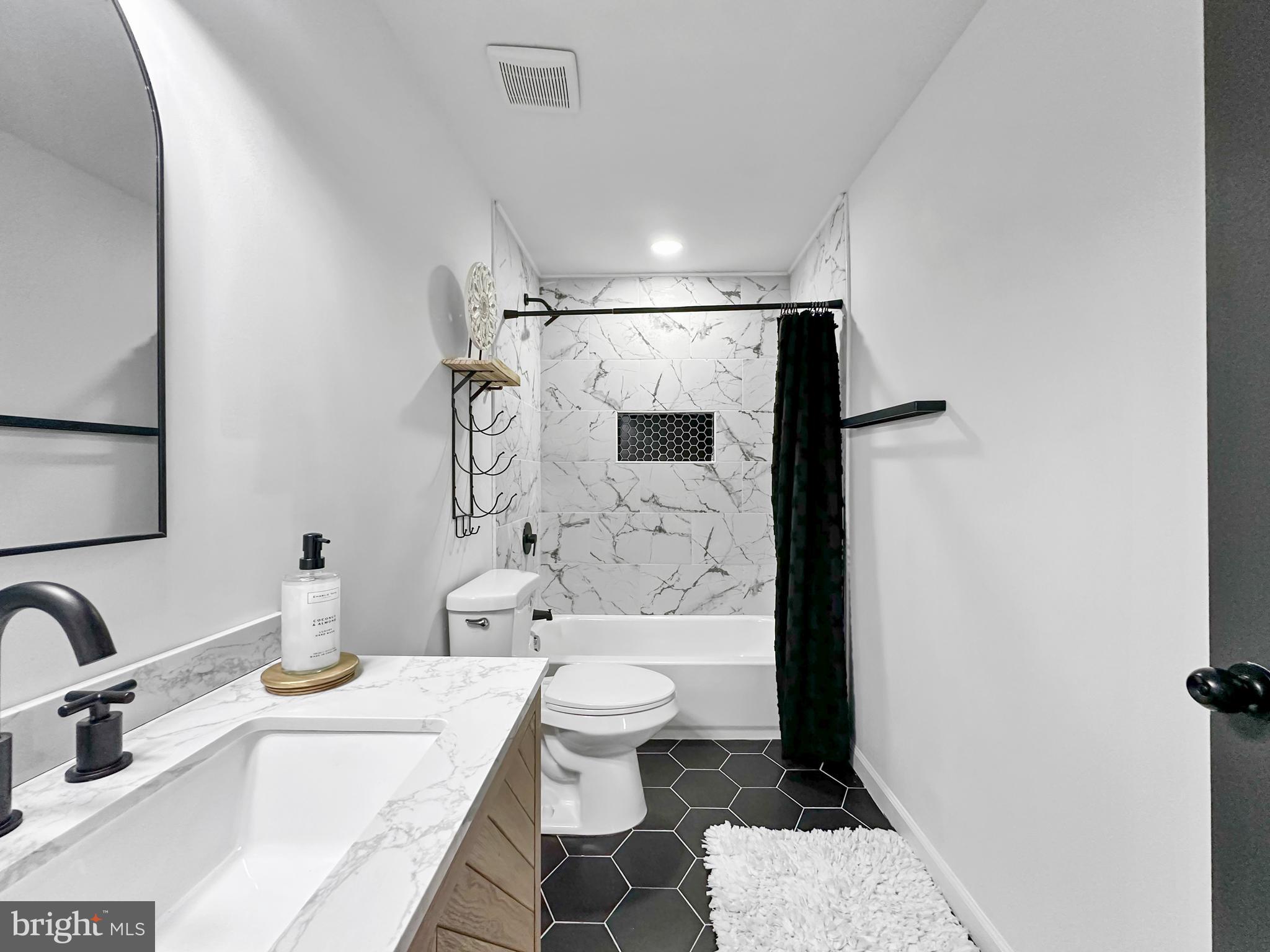 4309 Queensbury Road Riverdale, MD 20737 - Photo 45 of 63 a bathroom with a sink toilet and shower