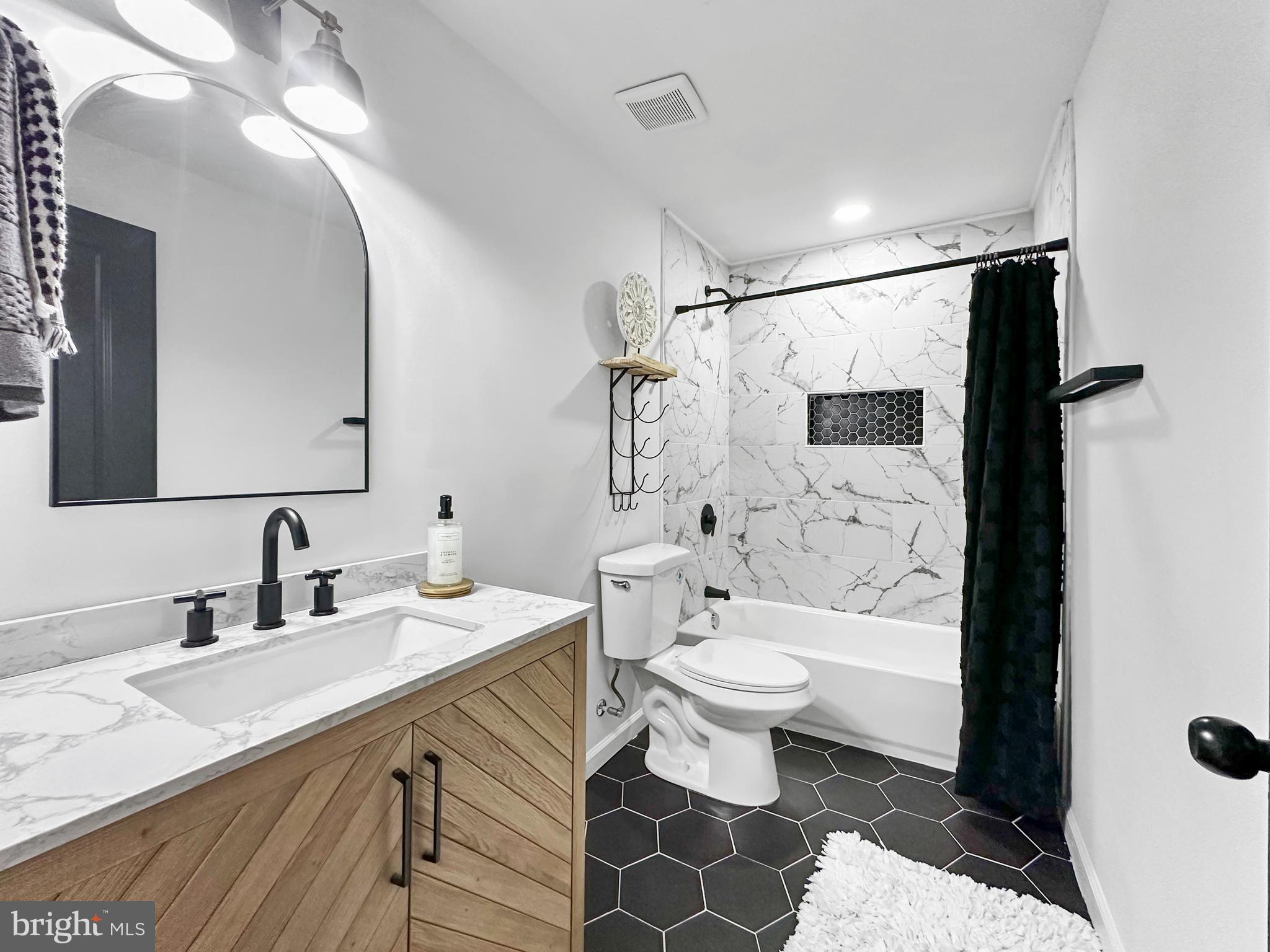 4309 Queensbury Road Riverdale, MD 20737 - Photo 47 of 63 a bathroom with a sink toilet a mirror and shower