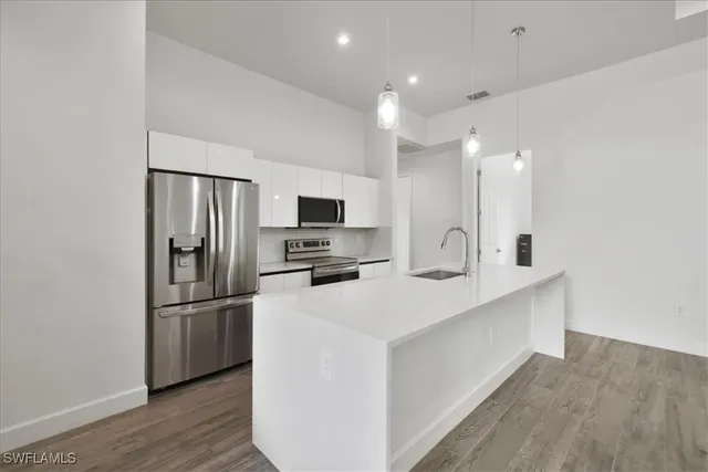 a kitchen with stainless steel appliances a refrigerator and a stove top oven
