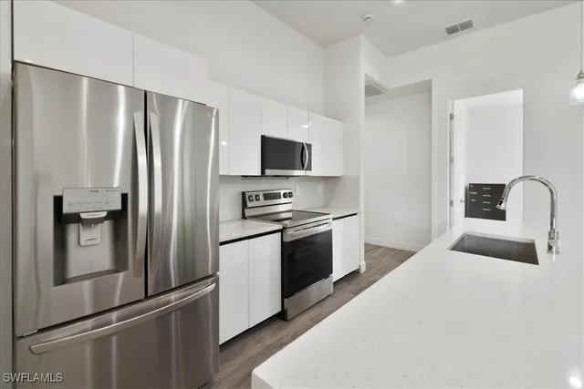 a kitchen with a refrigerator sink and stainless steel appliances