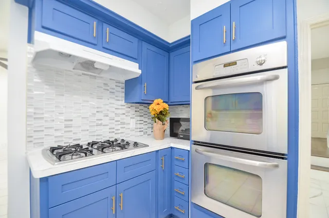 a kitchen with stainless steel appliances granite countertop a refrigerator and a stove top oven