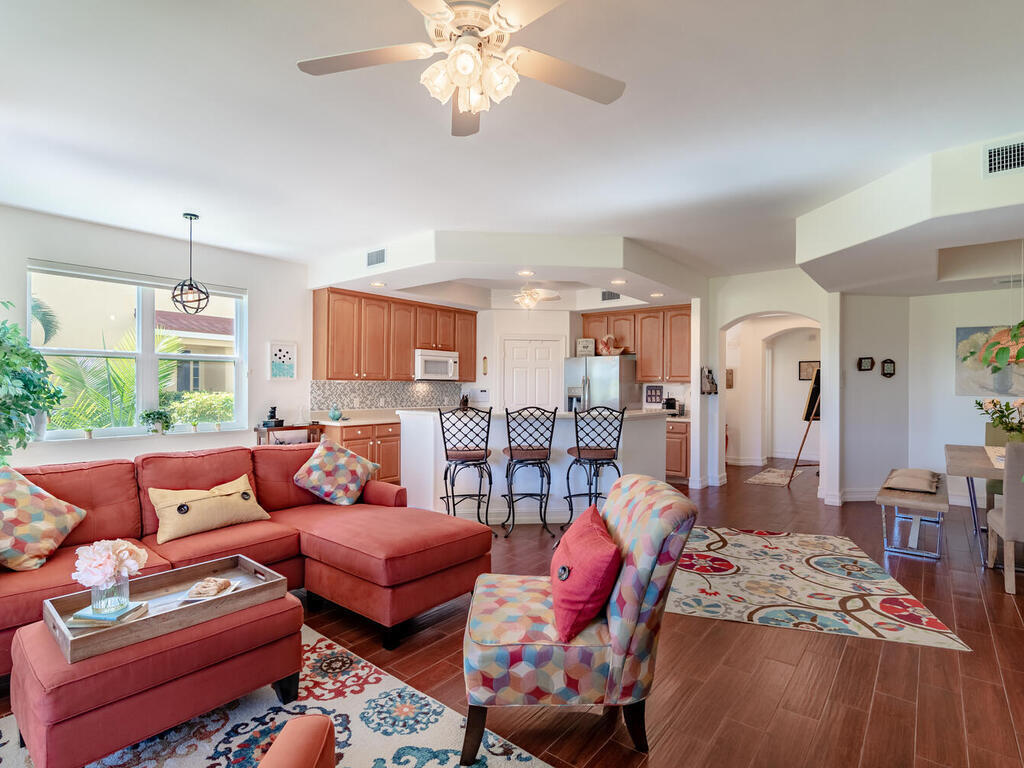1276 Rialto Way, Unit 102 Naples, FL 34114 - Photo 15 of 37 a spacious bedroom with a bed a couch and dresser