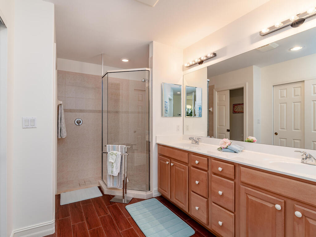1276 Rialto Way, Unit 102 Naples, FL 34114 - Photo 18 of 37 a bathroom with a double vanity sink toilet and shower