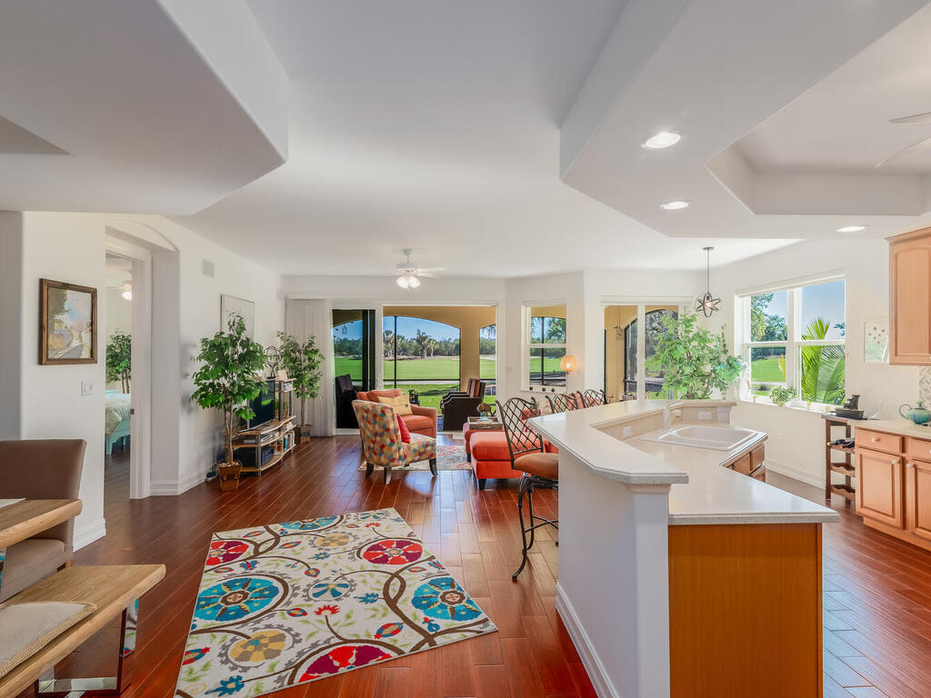 1276 Rialto Way, Unit 102 Naples, FL 34114 - Photo 3 of 37 a living room with furniture and a open kitchen view
