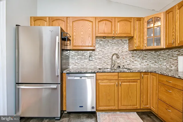 a kitchen with stainless steel appliances granite countertop a refrigerator and a sink