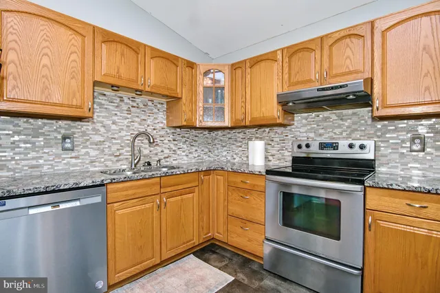 a kitchen with granite countertop cabinets stainless steel appliances and a sink