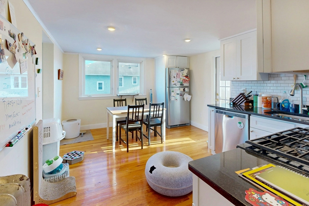 58 Dearborn Street Medford, MA 02155 - Photo 17 of 38 a kitchen with stainless steel appliances granite countertop a table and chairs in it
