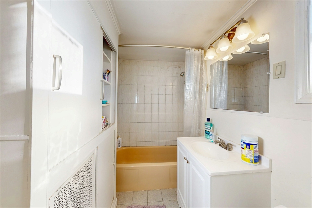 58 Dearborn Street Medford, MA 02155 - Photo 23 of 38 a bathroom with a tub a sink and a mirror