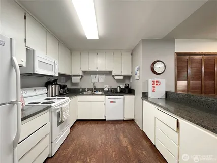 a kitchen with granite countertop stainless steel appliances sink stove and cabinets