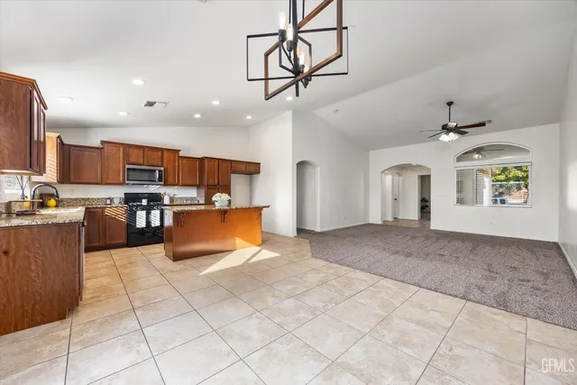 a kitchen with stainless steel appliances granite countertop a sink stove refrigerator and microwave