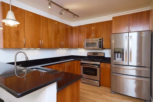 a kitchen with stainless steel appliances granite countertop a sink stove and refrigerator