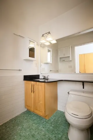 a bathroom with a sink a toilet and mirror