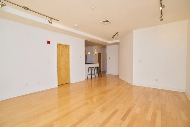 a view of empty room with wooden floor