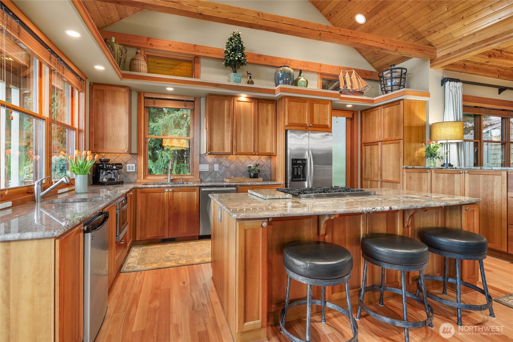 15550 Sandy Hook Road Northeast Poulsbo, WA 98370 - Photo 11 of 40 a kitchen with stainless steel appliances granite countertop table chairs sink and cabinets