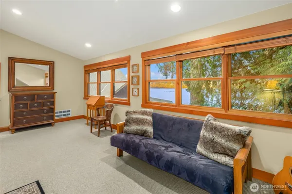 a bedroom with a bed and a couch next to a window