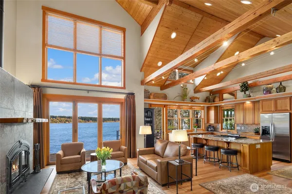 a living room with furniture a flat screen tv and floor to ceiling window