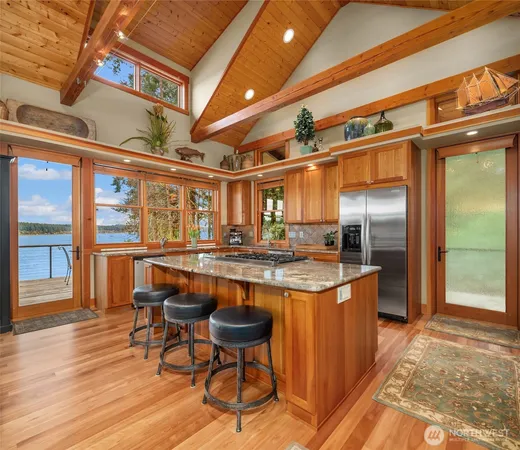 a kitchen with stainless steel appliances granite countertop a sink and wooden cabinets