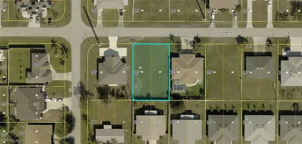 an aerial view of a residential houses with outdoor space and parking