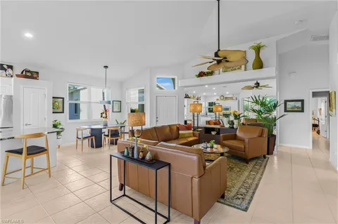 a living room with furniture kitchen view and a chandelier