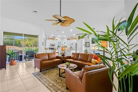 a living room with furniture a chandelier and a floor to ceiling window