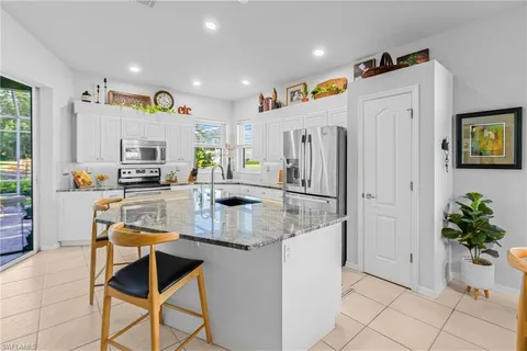 a kitchen with stainless steel appliances granite countertop a refrigerator and a stove top oven
