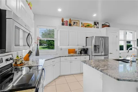 a kitchen with granite countertop a sink appliances cabinets and furniture