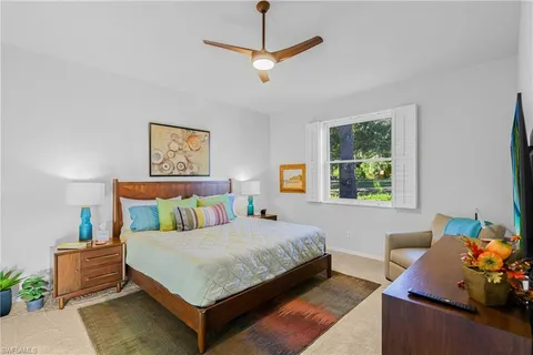 a bedroom with a bed a couch and a window