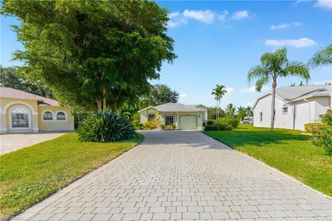a front view of a house with a yard and trees