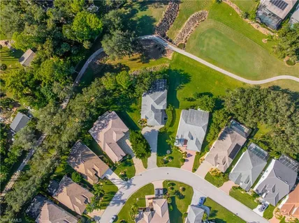an aerial view of residential houses with outdoor space and lake view