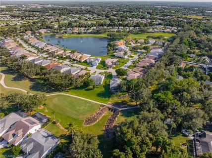 an aerial view of residential houses with outdoor space and trees