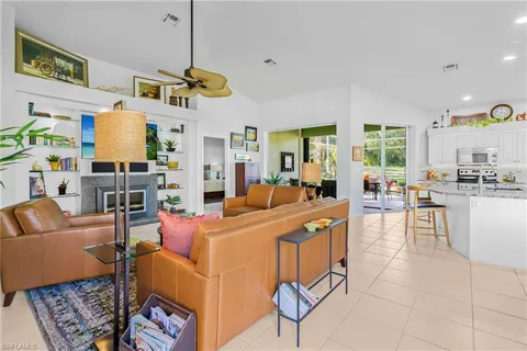 a living room with furniture kitchen view and a chandelier