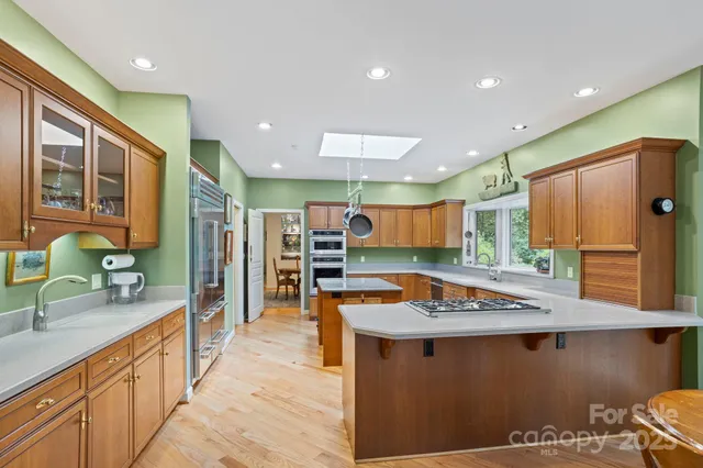 a kitchen with stainless steel appliances granite countertop a sink and a refrigerator