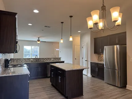 a kitchen with granite countertop a sink cabinets and stainless steel appliances