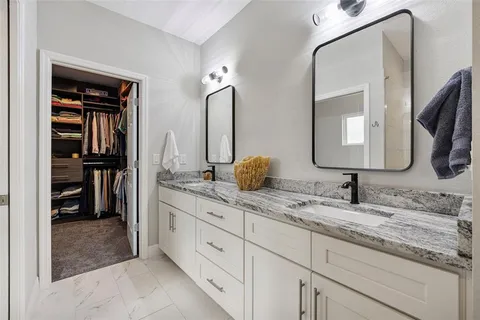 a bathroom with double vanity sinks and a mirror