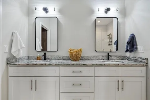 a bathroom with double vanity sinks and a mirror