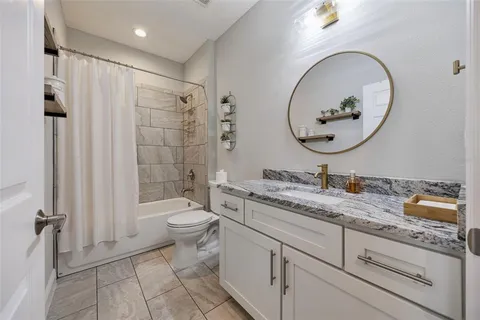 a bathroom with a granite countertop toilet a sink and a mirror