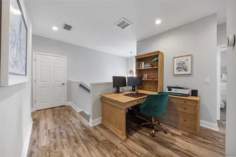 a view of a workspace with furniture and wooden floor