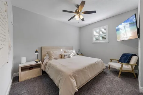 a bedroom with a bed a chair and a chandelier