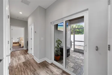 a view of a hallway with bathroom and wooden floor