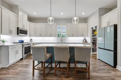 a kitchen with stainless steel appliances granite countertop a kitchen island hardwood floor and a sink