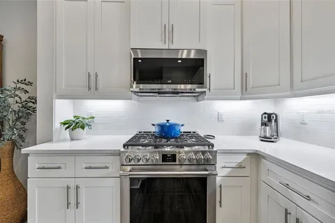 a kitchen with a stove and a white cabinets